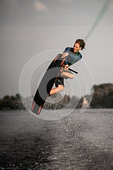 healthy strong guy doing an extreme jump on wakeboard