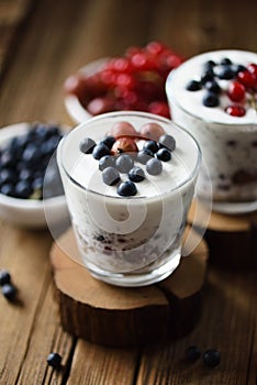 Healthy sugar free snack. Chia pudding with coconut cream and raw blueberries and currants on wooden background