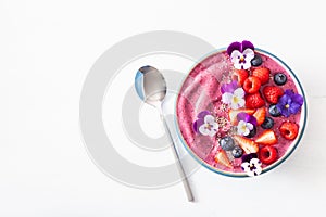 Healthy summer berry smoothie bowl with flowers and chia seed