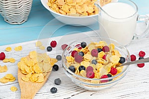 Healthy summer breakfast - cereal with milk and fresh berries in a bowl on the table. Light wooden background. Healthy