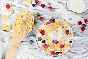 Healthy summer breakfast - cereal with milk and fresh berries in a bowl on the white wooden table. Healthy eating