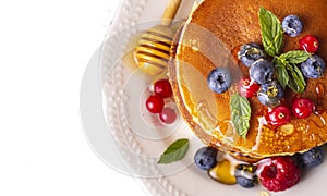Healthy summer breakfast, homemade classic american pancakes with fresh fruit and honey.