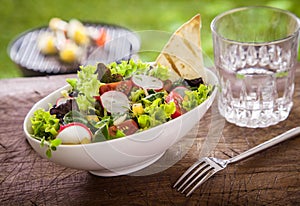 Healthy summer salad with a glass of fresh water