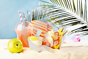 Healthy summer vacation, relax and beach play on tropical beach with cold drink, ice cream, fruit salad, sun hat under palm leaves