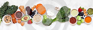 Healthy super food ingredients. Top view table scene on a white marble banner background.
