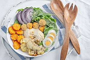 Healthy superbowl or Buddha bowl with salad, baked sweet potatoes, chickpeas,