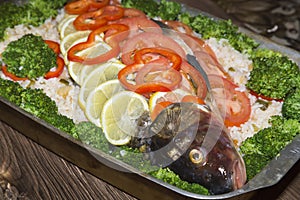 Healthy tasty homemade food. Fish appetizing vitamin dish with vegetables. Raw river carp stuffed with rice, fresh tomatoes, peppe
