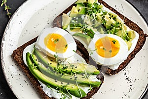 Healthy tasty toast with avocado, white cheese and boiled egg. Food recipe background. Close up. top view