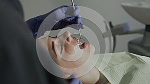 Healthy teeth of the patient. The dentist examining his patient`s teeth through the mirror