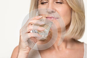 Healthy thirsty senior old woman drinking water isolated on background