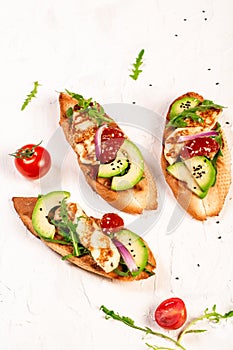 Healthy toasts with grilled Halloumi cheese and slices of avocado on a light background. Healthy vegetarian food. Top view,