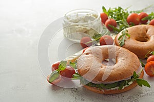 Healthy turkey ham sandwich on a bagel with greens and tomato. Breakfast. Copy space