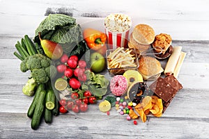 Healthy or unhealthy food. Concept photo of healthy and unhealthy food. Fruits and vegetables vs donuts and fast food photo