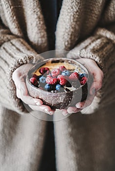 Healthy vegan breakfast bowl with oats in womans hands