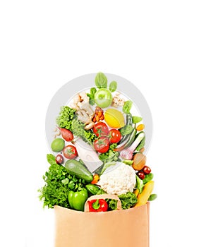 Healthy vegan food in full paper bag, vegetables and fruits on white background, copy space, banner. Shopping food, supermarket,