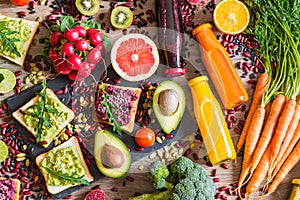 Healthy vegan food. Sandwiches and fresh vegetables on wooden background. Detox diet. Different colorful fresh juices. top view