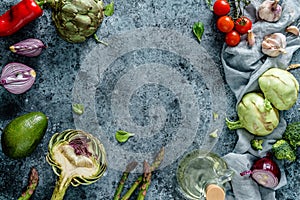 Healthy vegan ingredients layout. Flat-lay of green vegetables and herbs over light blue background with napkin, top view, copy