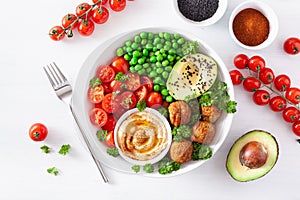 Healthy vegan lunch bowl with falafel hummus tomato avocado peas