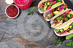 Healthy vegan mushroom tacos. Overhead view on a dark slate background with copy space.