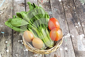 Healthy vegetable bok choy egg tomato in basket on wood table