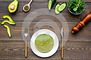 Healthy vegetable pancake. Spinach pancakes served with cucumber, avocado and greenery on dark wooden background top