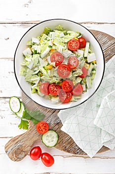 Healthy vegetable salad of chinese cabbage, corn, cucumbers and tomatoes. Delicious vegetarian dietary lunch. Vegan food. Top view