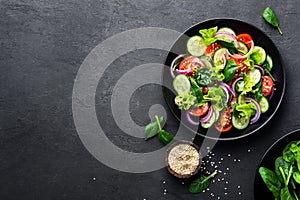 Healthy vegetable salad of fresh tomato, cucumber, onion, spinach, lettuce and sesame on plate. Diet menu