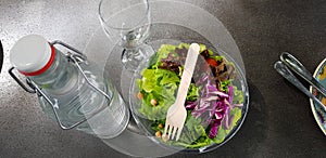 Healthy vegetable salad of fresh tomato, lettuce and red cabbage with wooden spoon and caesar salad dressing