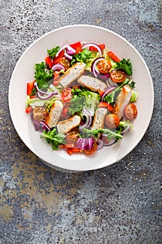 Healthy vegetable salad with grilled chicken breast, fresh lettuce, cherry tomatoes, red onion and pepper