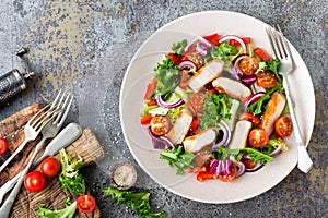 Healthy vegetable salad with grilled chicken breast, fresh lettuce, cherry tomatoes, red onion and pepper