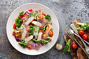 Healthy vegetable salad with grilled chicken breast, fresh lettuce, cherry tomatoes, red onion and pepper