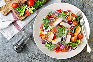 Healthy vegetable salad with grilled chicken breast, fresh lettuce, cherry tomatoes, red onion and pepper