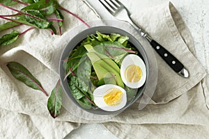 Healthy vegetarian breakfast bowls with salad, avocado and egg, top view. Clean eating, diet food concept