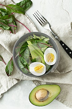 Healthy vegetarian breakfast bowls with salad, avocado and egg, top view. Clean eating, diet food concept