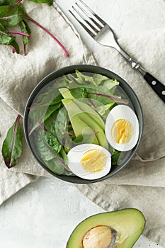 Healthy vegetarian breakfast bowls with salad, avocado and egg, top view. Clean eating, diet food concept