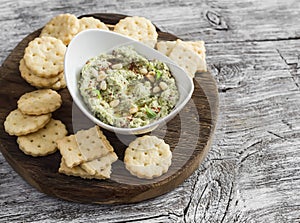 Healthy vegetarian broccoli and pine nuts hummus and homemade cheese biscuits on a wooden rustic board.