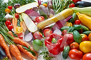 Healthy vegetarian diet food background. Various fresh organic vegetables on the white table: tomatoes, sliced zucchini, beet