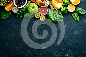 Healthy vegetarian food: Orange, lemon, apple, rose, garlic, broccoli, apple, kiwi, spinach. Top view.