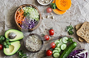 Healthy vegetarian food set background with free space for text. Cabbage, avocado, tomatoes, cucumbers, pumpkin, wild rice on a pa