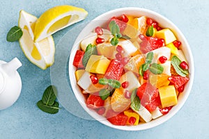 Healthy vegetarian fresh fruit salad with apple, pear, tangerine, grapefruit, mango, pomegranate and lemon juice. Top view