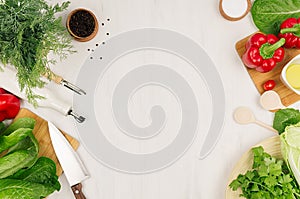 Healthy vegetarian ingredients for spring fresh green salad and kitchenware on white wood board, top view, copy space.