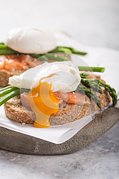 Healthy vegetarian meal. Toast,  poached egg, asparagus, salmon fish. Stone background. Clean eating Diet. Organic food