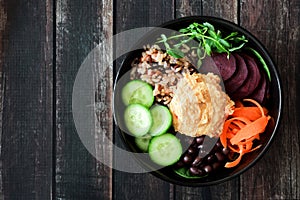 Healthy vegetarian nourishment bowl on dark wood