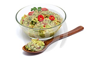 Healthy vegetarian organic guacamole Mexican dip sauce served in glass bowl with nachos or tortilla chips isolated on