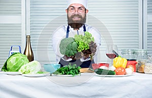 Healthy vegetarian recipe. Man cook hat and apron hold broccoli. Organic vegetables. Healthy nutrition concept. Bearded