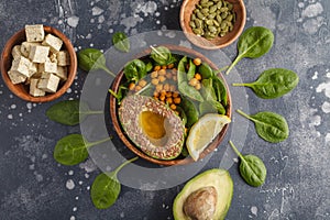 Healthy vegetarian salad with tofu, chickpea, avocado and sunflower seeds. Healthy vegan food concept. Dark background, top