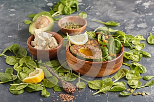 Healthy vegetarian salad with tofu, chickpea, avocado and sunflower seeds. Healthy vegan food concept. Dark background, copy