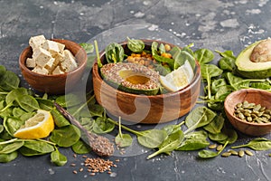 Healthy vegetarian salad with tofu, chickpea, avocado and sunflower seeds. Healthy vegan food concept. Dark background, copy