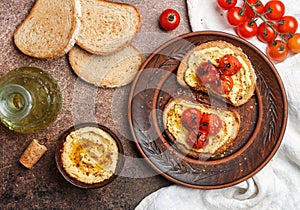 Healthy vegetarian sandwiches with whole grain bread, hummus, baked tomatoes and spices