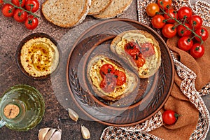 Healthy vegetarian sandwiches with whole grain bread, hummus, baked tomatoes and spices